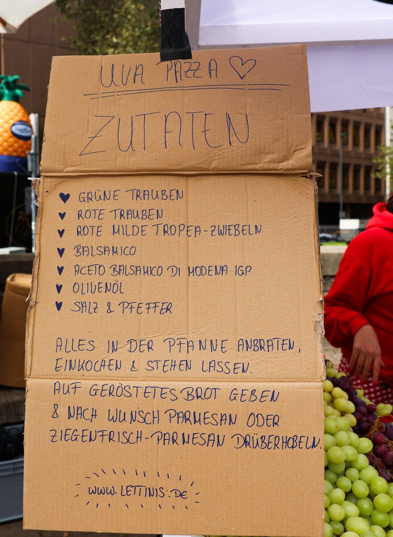 Handgeschriebenes Pappschild mit den Zutaten der Uva Pizza vom Showcooking
