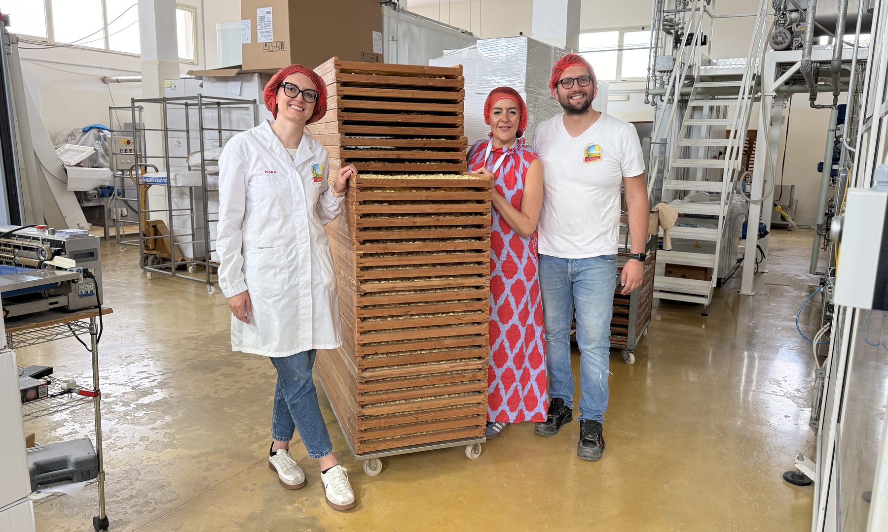 Mara De Santis, Stefania Lettini und Vincenzo De Santis vor einem Turm aus Holzrahmen mit trocknender Pasta