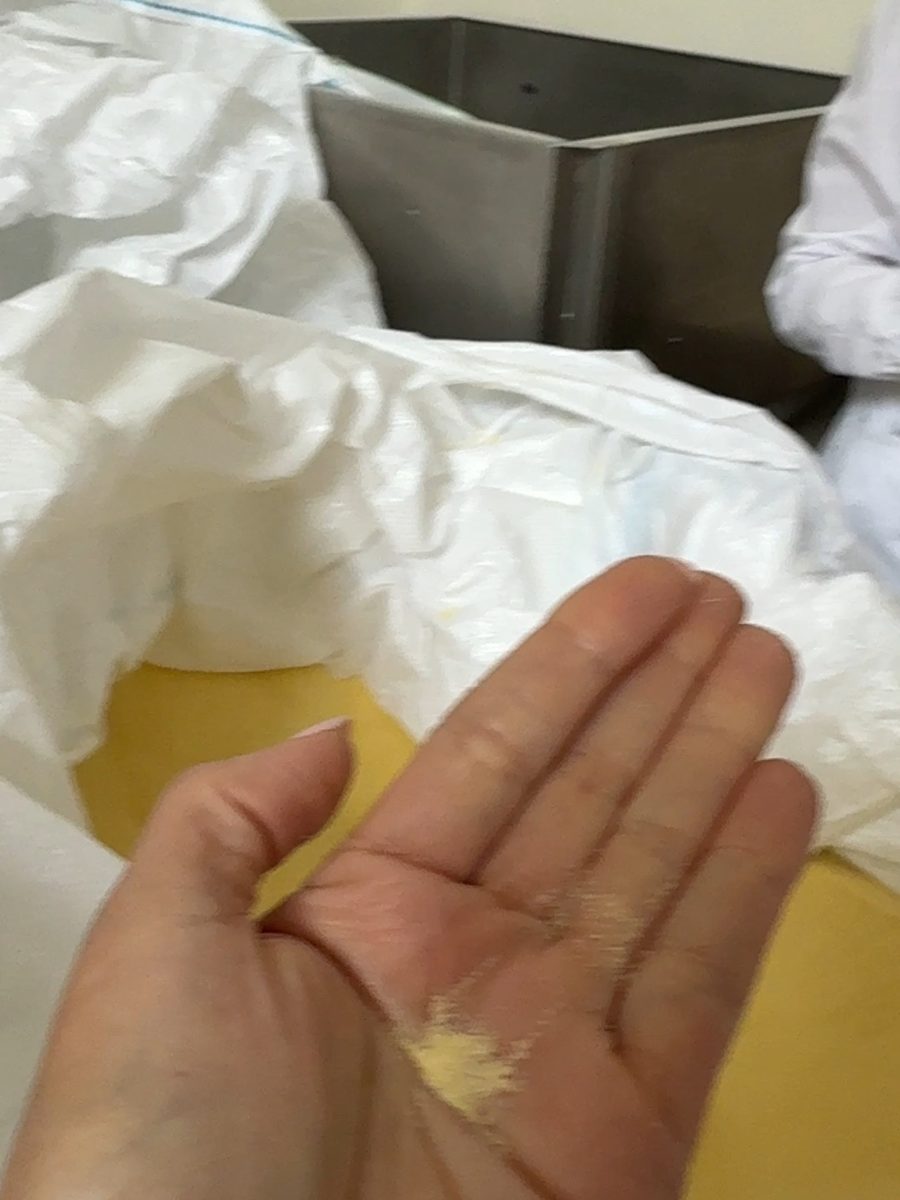 Eine Prise Semola in der Hand, dahinter der offene Sack