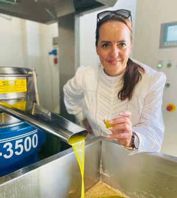 Lucia di Molfetta an der Ölmühle, mit einem Glas frischem Öl