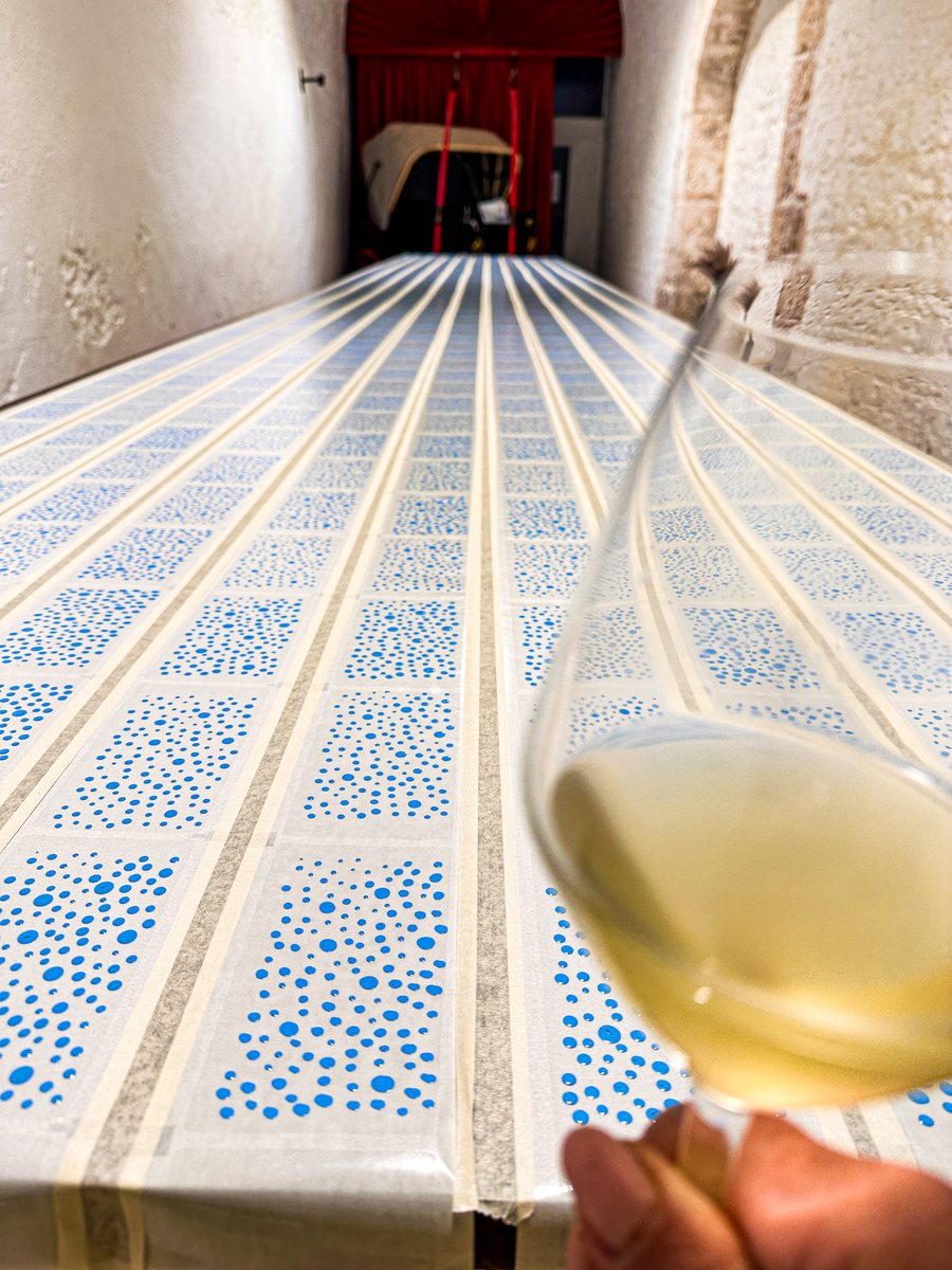 Ein Glas Weißwein über den bedruckten Bahnen