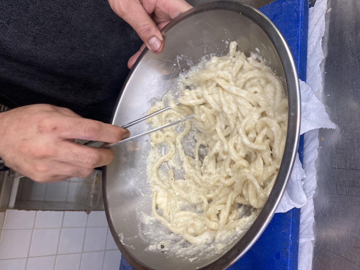 Pici werden in der Pfanne geschwenkt